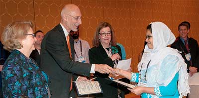Dr. Robin Dibner joins Bob Nemanich and Laura Greene present an Ovshinsky award to Saima Siddiqui