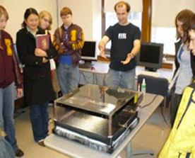 A graduate student demonstrates a cloud chamber for students participating in a Masterclass day at the University of Minnesota.