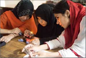 Woman at table at Post IYL inspired outreach at Quaid-i-Azam University